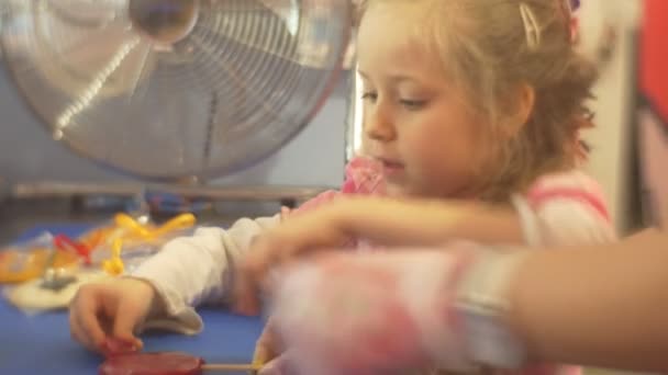 Παιδί χύτευση μια καραμέλα διακόσμηση ένα κόκκινο καραμέλα μαθαίνουν να κάνουν εκδρομή γλυκά γλυκά εργοστάσιο καραμέλα σε ένα ραβδί ζαχαροπλάστη διδάσκει το παιδί — Αρχείο Βίντεο