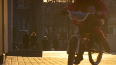 Küçük kız tarafından şehir Street insanlar siluetleri güneş kaldırım taşları çocuk akşam Sunset kızın siluet bir bisiklet sürme binmek için öğrenme