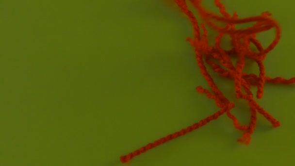 Couper des morceaux de fil sur l'écran vert tombent les fils de laine Fils colorés Couper des morceaux de fils Quelqu'un met le fil vers le bas prend vers le bas 