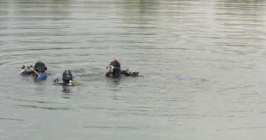 Üç adam dalgıçlar Mavi palet su söz dalgıç erkek dalgıçlar mayo siyah takım elbiseli gözlük tüpler içinde yüzme su dalgalanan duruyorsun