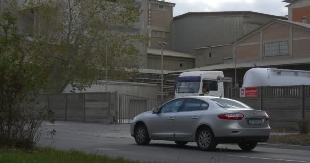 Le auto stanno passando su strada Camion dei pompieri rossi L'uomo in bicicletta La donna sta camminando vicino ai serbatoi stradali sta lasciando la fabbrica Opole Polonia — Video Stock