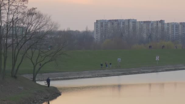 Lidí na promenádě růžový večer Sky zpevněné břehu řeky oblohy se odráží ve vodní povrch Odra River Opole Polsko bezvětří večer venku — Stock video