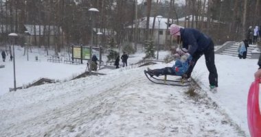 İnsanlar Park Çocuklar Ride Sled Little Boy Ride Hill Üstüne Bir Kızak Oturur Annesi Karlı Kış Günü Kiev Ukrayna yakınında duruyor