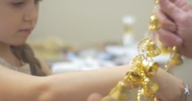 Kız ile onun babası dedesi çöz dolaşmış Garland altın çan önce yeni yıl ağacı çam adam için çelenk O'nun elinde tutan koyarak
