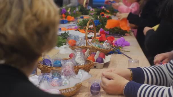 人々 が作る紙花イースターエッグ色とりどりの花とのお祝いに家族のマスター クラス オポーレ準備でテーブルに飾りと卵 — ストック動画