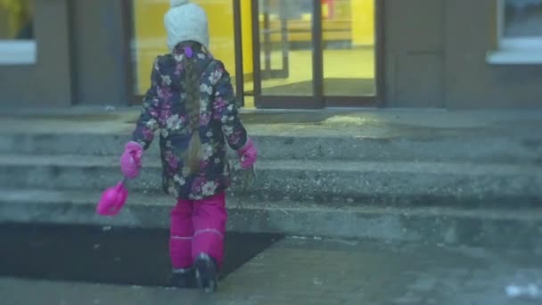 Niña está caminando a casa por las escaleras Entradas Las puertas de la casa se abren automáticamente sosteniendo una pala y ramas Invierno Slow Motion Frosty Flowered Jacket — Vídeos de Stock