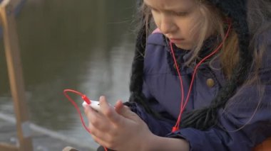 Şezlong su ve dinleme müzik bir iskele akşam zaman güneşli gün Opole Polonya açık havada üzerinde dinlenme nehirde Şehir Parkı sarışın kız çocuk oturur