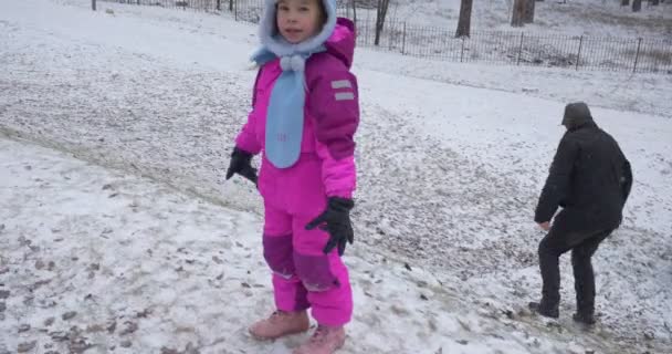 爸爸帮助女孩爬山妈妈给手其他孩子骑从山上雪人散步和发挥在公园雪冬日基辅乌克兰 — 图库视频影像