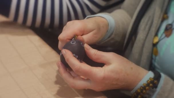Mulher está fazendo ovo preto de Páscoa cortando ornamento na família Master Class Opole Polônia se preparando para a celebração da Páscoa Famílias estão trabalhando juntas — Vídeo de Stock