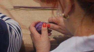 Violet Paskalya yortusu yumurta kesme dışarı bir desen ile bıçak otururken bir Paskalya kutlamaları aile Opole Polonya tablo hazırlamaya, kıdemli kadındır