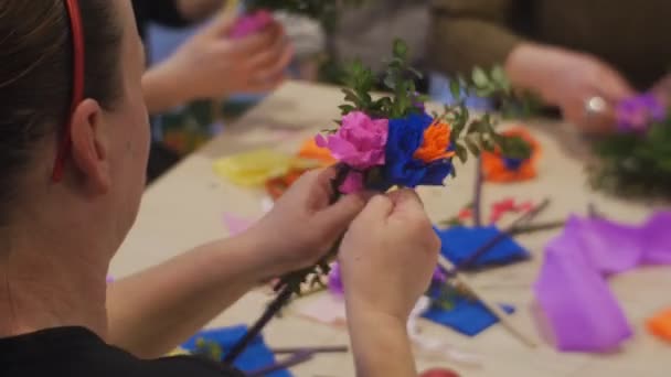 La donna sta legando un mazzo di fiori di carta alla classe Master della famiglia Opole Polonia Preparazione alla celebrazione di Pasqua Carta colorata su una tavola — Video Stock