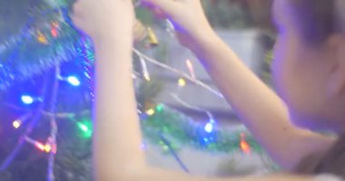 Kız altın bir koni yeni yıl ağacı çam çelenk dekore edilmiş ve Lamplights için eve meraklı kızım bir şube aile kutlama koyarak