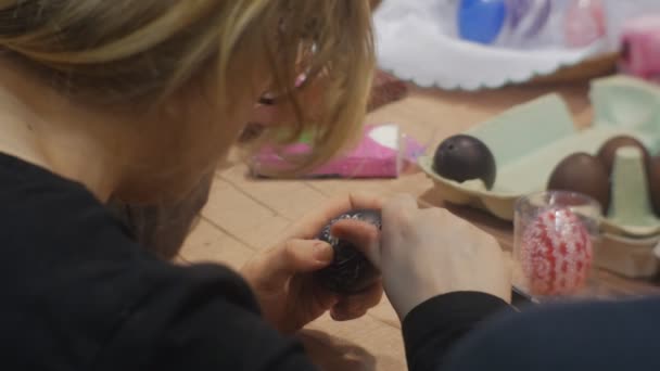 Mujer está haciendo huevo de Pascua negro en la mesa cortando el ornamento en la clase maestra de la familia Opole Polonia Preparándose para la celebración de Pascua Trabajando juntos — Vídeos de Stock