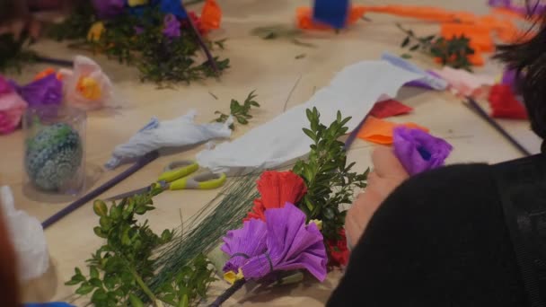 Kvinnan är bindande upp ett papper blommor att göra Påsk bukett på familjen Master Class Opole Polen förberedelse till firandet färgglada papper på ett bord — Stockvideo