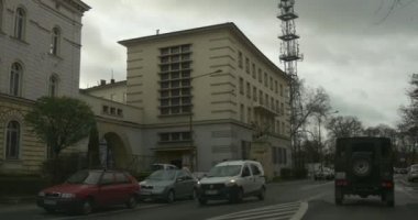 Bu içinde kamera ile araba hareket yavaş yavaş şehir cadde boyunca bir eski binalar diğer araçları yol bulutlu gün güneş ışığı ile bulutların üzerinde etkinleştirmektir