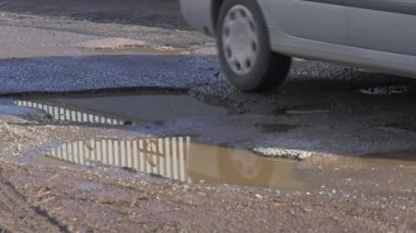Gümüş araba araç su birikintileri otomobilin tekerlekleri tampon su bir su birikintileri Düzeltilmemiş yol güneşli gün gökyüzü yansıması bir su Opole Polonya tarafından tahrik edilmektedir
