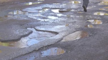 Adam çalıştıran uzak Getting geri ıslak yol su birikintileri ayak yakın kahverengi ayakkabı ıslak asfalt sonra yağmur gökyüzü yansıma tarafından su güneşli bir günde kış bahar olduğunu.