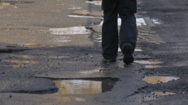 Adamın bacakları atlar sonra su güneşli bir kış veya bahar gökyüzü yansıma yağmur şehir sokak ıslak asfalt tarafından yürüyüş su su birikintileri üzerinden