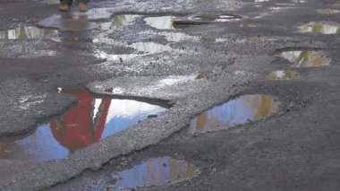Atlama yoluyla su birikintileri suda çukurlar çalıştırarak ıslak yol ayakları ıslak asfalt sonra yağmur gökyüzü yansıma bir su Sunny gün kış bahar kadar yakın biri