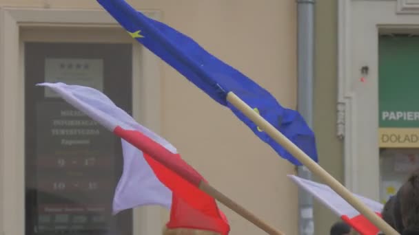 Två vajande flaggor polska röda och vita flaggan eu blå flagg demokratiska mötet Opole Polen Protest mot the presidentens politik kvinnor i Red Hat promenader — Stockvideo