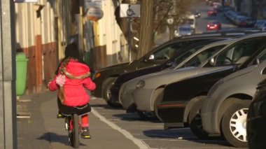 Küçük kız sürme aşağı hızlı Şehir Meydanı Opole Polonya şehir gün çocuk tarafından bir bisiklet ile şehir sokakları güneşli gün bahar zamanında biniyor olduğunu