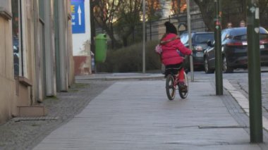Yavaş yavaş şehir sokak Opole Polonya şehir gün çocuk tarafından Bisiklet Upward sürme sürme arasında kalabalık, insanlar tarafından bir cadde Sunny gün bahar yürüyor kız