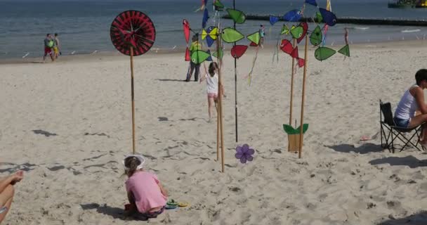 Familjer sitter på sand och sola på solen — Stockvideo