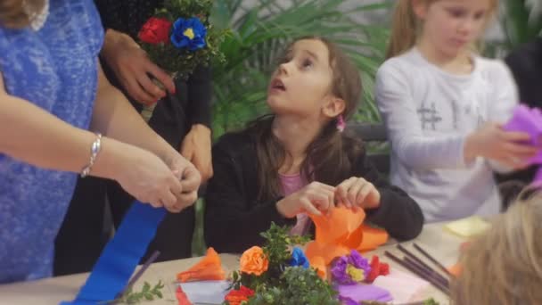 Lidé, kteří se valí papírové květiny v rodinném mistrovi třída Opole Polsko vazba na Bouquety Příprava na velikonoční oslavy barevný papír na stole — Stock video