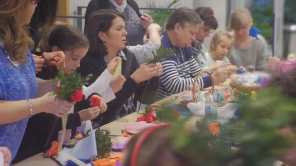 Kvinnor Män Barn gör papper Blommor Familj Master Class Opole Polen Förberedelse till firandet Färgade påskägg på ett bord färgat papper — Stockvideo