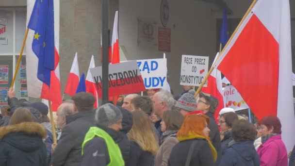 Участники митинга "Люди с плакатами демократии" в Польше против президента Эндрю Дуды активисты размахивают польскими и европейскими флагами — стоковое видео