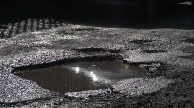 Araç ıslak yol su birikintileri güneş parlar su bir çukurlar otomobilin tekerlekleri güneşli gün güneş yansıması açık havada bir su ıslak asfalt düzeltilmemiş yol tarafından tahrik edilmektedir