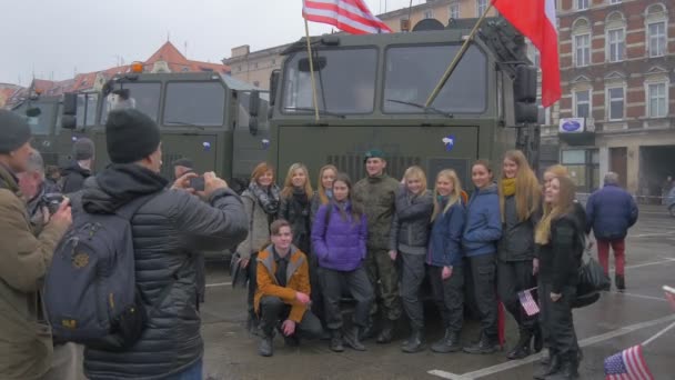 Ludzie biorący zdjęcie wycieczka obóz wojskowy Opole Atlantic Resolve operacja szczęśliwy młodych ludzi w pojeździe żołnierzy w kamuflażu Waving flagi City Square — Wideo stockowe