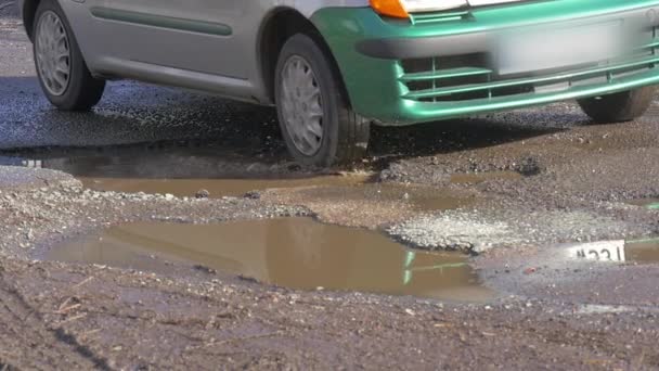 Dubbel färgade bil suddiga antal fordon drivs av pölar bilens hjul stötfångare vatten i pölar oreparerade Road himlen återspeglar i ett vatten Opole Polen — Stockvideo