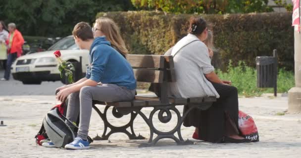 Een man zit op de Bank in de buurt van zijn vriendin — Stockvideo