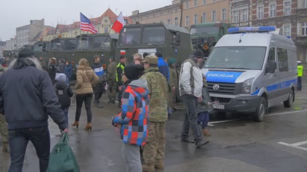 Wycieczka do obozu wojskowego Opole People patrząc na vahicles Waving flagi Atlantic Resolve operacja żołnierze w kamuflażu sprzęt wojskowy plac miejski — Wideo stockowe