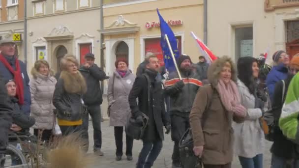 Activistas saltan coreando reunión democrática Opole Polonia protesta contra las políticas del presidente Hombres y mujeres ondean banderas polacas y europeas sonriendo — Vídeo de stock