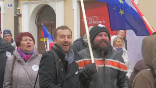 Прыгающие люди скандируют на демократическом митинге в Ополе Протест против президентской политики Два мужчины улыбаются пожилым женщинам с польскими флагами ЕС — стоковое видео