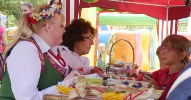 Deelnemers van de dag van voorschoolse kinderen hebben verborgen voor de hete zon onder een luifel. — Stockvideo