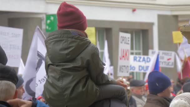 Kid on taty na szyi tłum na demokratyczny Rajd przeciw prezydentowi Andrew Duda działania Opole Polska ludzie działacze trzymają bannery Waving polskie flagi — Wideo stockowe