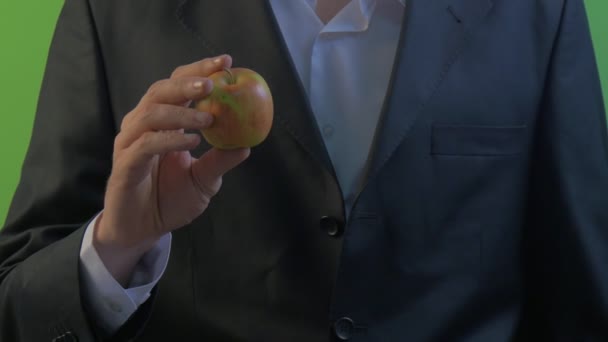 Man is holding an Apple Shows the Fruit Green Screen Man 's Hands Young Businessman in White Shirt and Black Suit Hand in Golden Ring on a Finger — стоковое видео