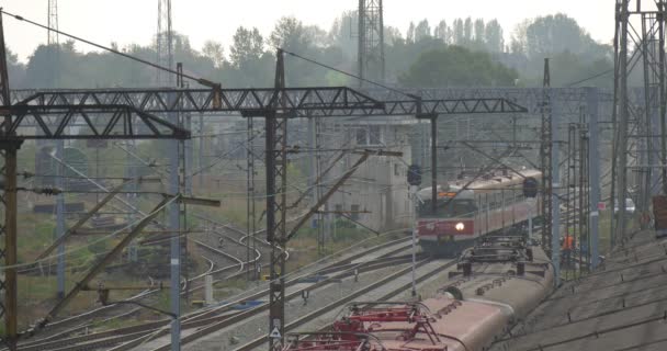 Red Electric Train Moves Away Railroad Train and Contact Network Lamp Posts Semaphores Rainy Autumn Day Fog Opole Poland — стоковое видео