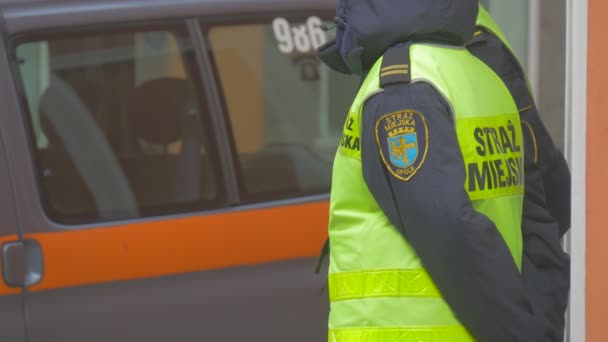 Двое полицейских на митинге в Опольском комитете защиты демократии польской полиции на своем автомобиле стоят в однородных желтых жилетах в городе — стоковое видео