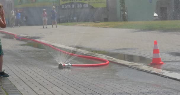 Stad dag Opole kinderen spelen in het Water van de straat is gespoten uit een slang aan een zomer Street tijdens de feest Happy Kids actief spelen en lachend — Stockvideo