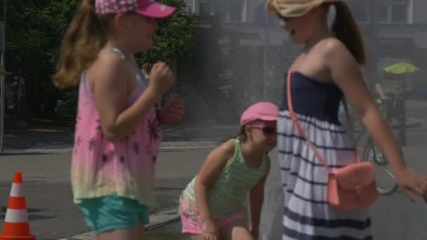 Chica vestida con una camiseta verde y pantalones cortos rosados corre por la calle — Vídeo de stock