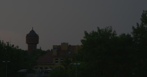 夜鈍い灰色空シルエットの家タワー ・木静かな場所放棄された建物夜レクリエーション ・暗闇の中での都市の建物ない人 — ストック動画