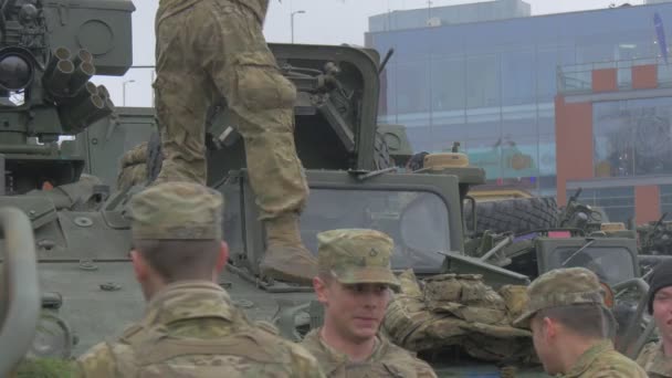 戦車砲塔のハッチに装備を入れる迷彩で兵士NATO作戦オポール男性が話し、物事のパレードを集めて微笑んでいる — ストック動画
