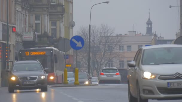 Paysage urbain d'Opole Jour de la ville Pologne Jour du printemps pluvieux Les voitures du crépuscule sont conduits par la route Bus de la ville Les gens traversent la route Vieux bâtiments anciens Clocher — Video