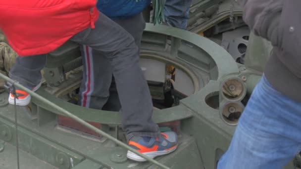 ティーンエイジャーは、オポールポーランドのパレードNATO作戦を見ている軍用車両で子供たちと遊ぶパンツァー兵士のハッチに入っています — ストック動画