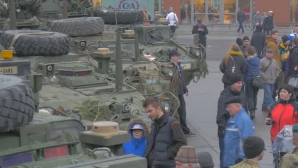 Pessoas caminhando ao longo de veículos militares estacionados Operação da OTAN em Opole Polônia Soldados em caminhões de camuflagem Pessoas estão andando pela Praça da Cidade Dia Nublado — Vídeo de Stock