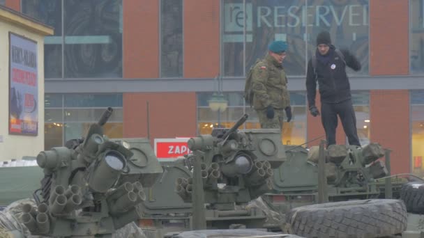 Солдат показує, танкова для цивільного людини операції НАТО в Ополе парад військових транспортних засобів люди вивчають зброю ходьба по міській площі похмурий день — стокове відео